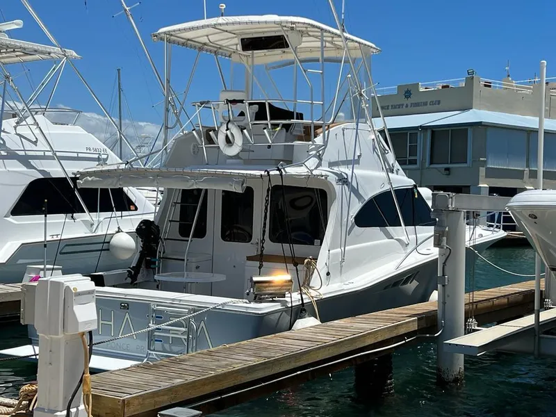 Slide: The Image of 1994 Luhrs 380 Tournament boat docked at a marina, featuring a flybridge and fishing equipment. - 9