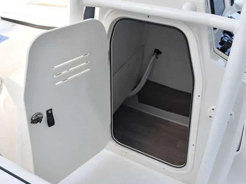 Slide: The Image of 2023 Stingray 206cc boat storage compartment with open door. - 12