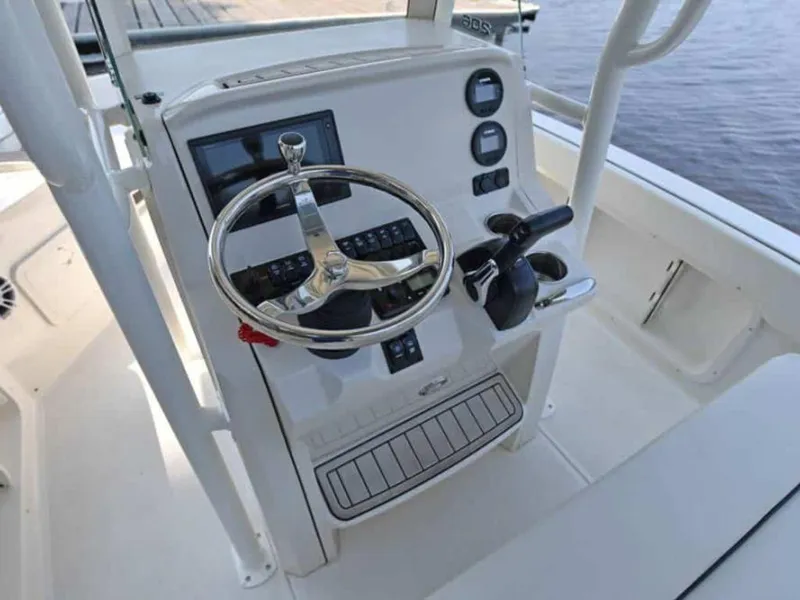 Slide: The Image of 2023 Stingray 206cc boat helm with steering wheel and control panel. - 3