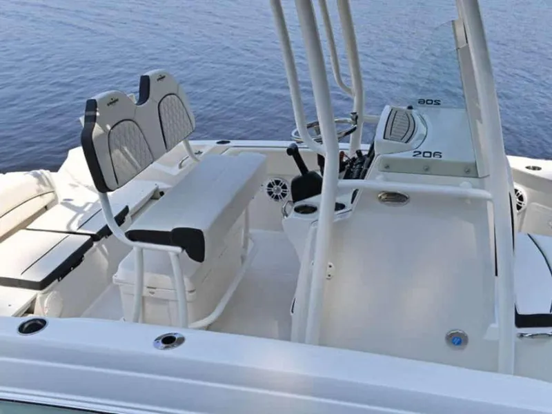 Slide: The Image of 2023 Stingray 206cc boat interior with seating and console, docked on calm water. - 4