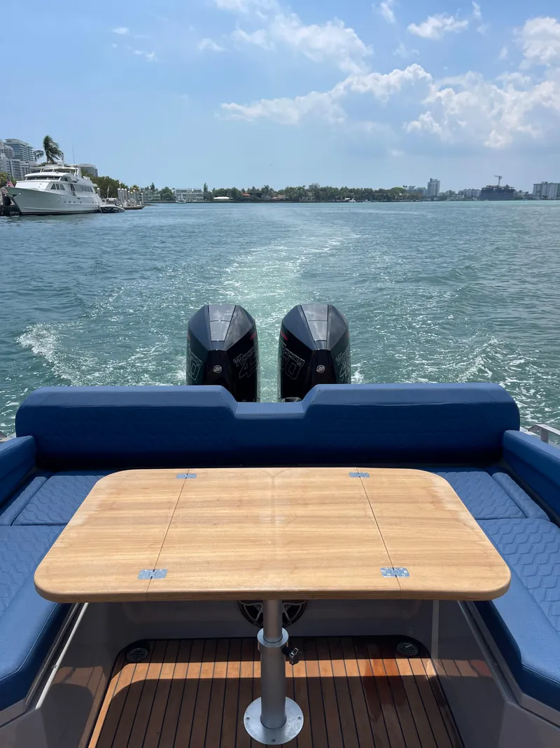 Slide: The Image of Skipper-BSK 38 boat, 2024 model, with twin engines and a wooden table, cruising on a sunny day. - 15