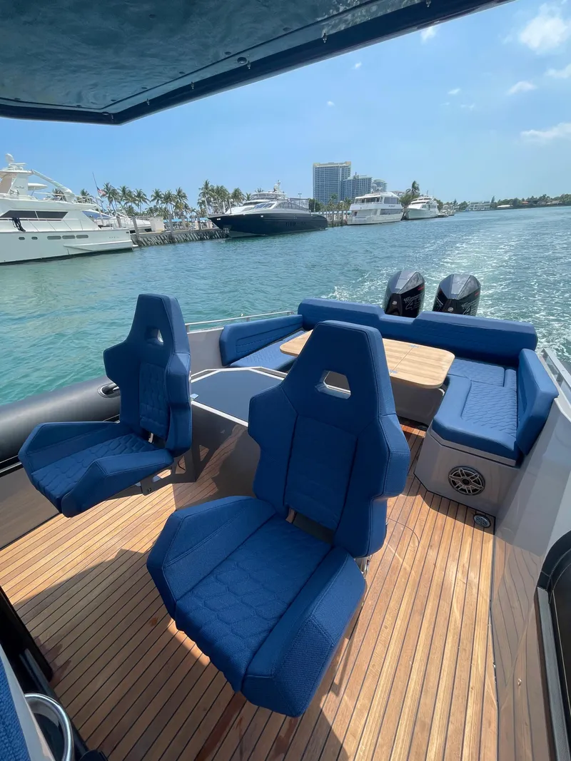 Slide: The Image of 2024 Skipper-BSK 38 boat with blue seating and wooden deck on the water. - 16