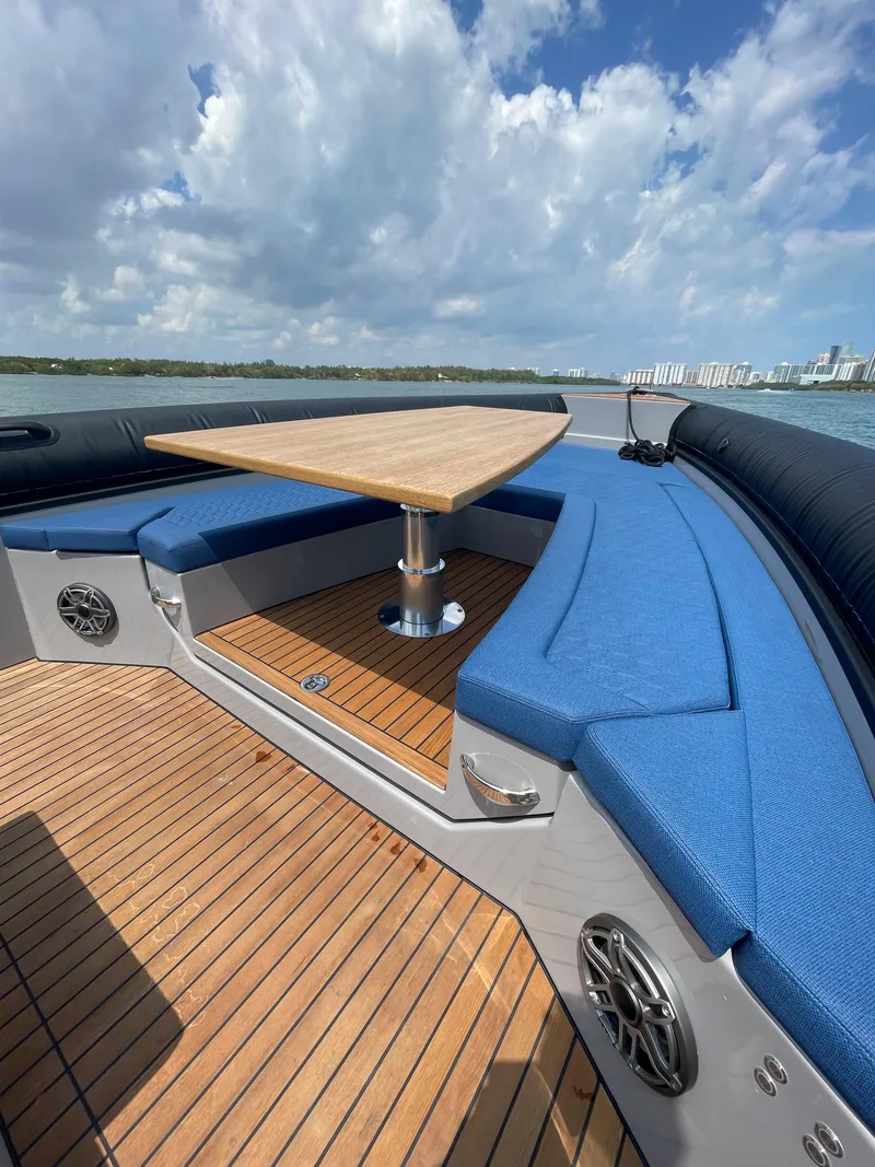 Slide: The Image of 2024 Skipper-BSK 38 boat with blue seating and wooden deck on a sunny day. - 23