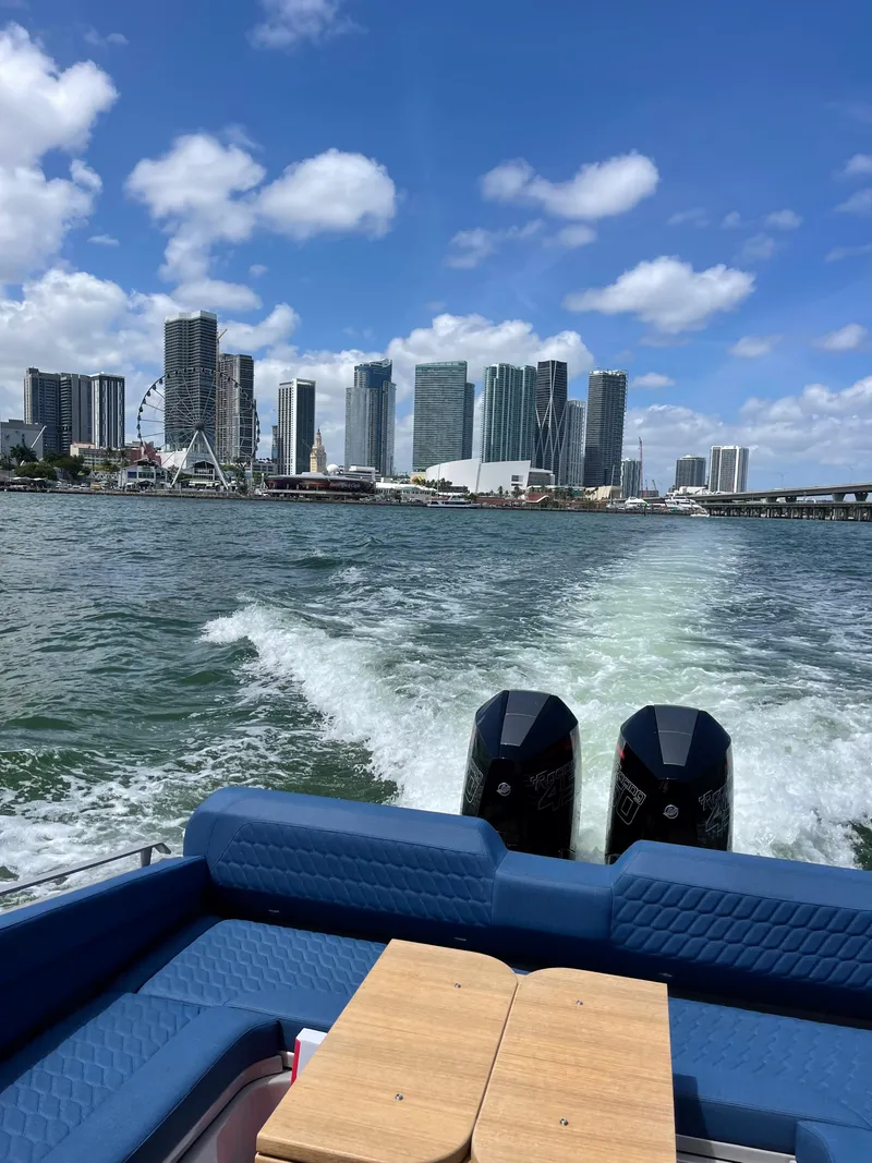 Slide: The Image of Skipper-BSK 38 boat cruising with city skyline in background, 2024 model. - 26