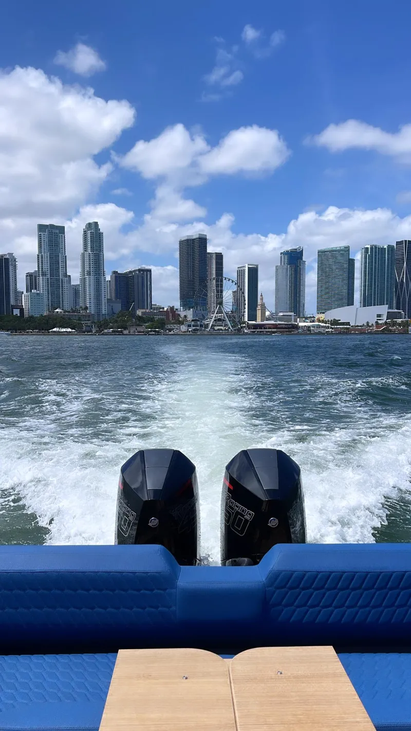 Slide: The Image of Skipper-BSK 38 boat cruising with city skyline in the background, 2024 model. - 27