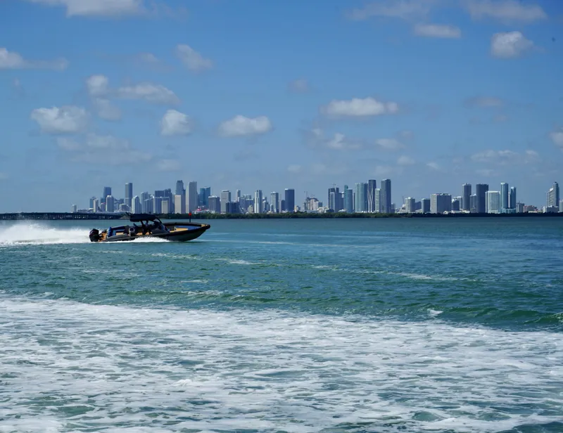 Slide: The Image of Skipper-BSK 38 boat cruising near city skyline, 2024 model. - 5