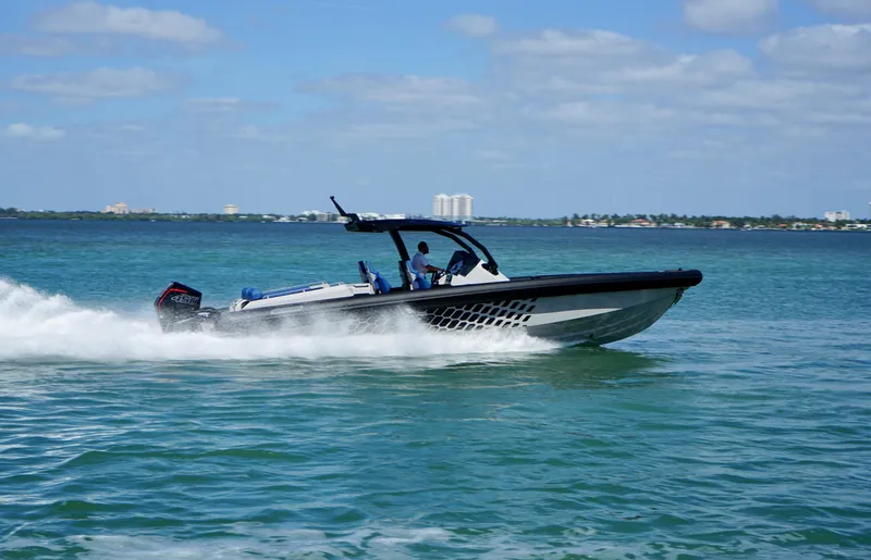 Slide: The Image of 2024 Skipper-BSK 38 boat speeding on open water under a clear sky. - 6