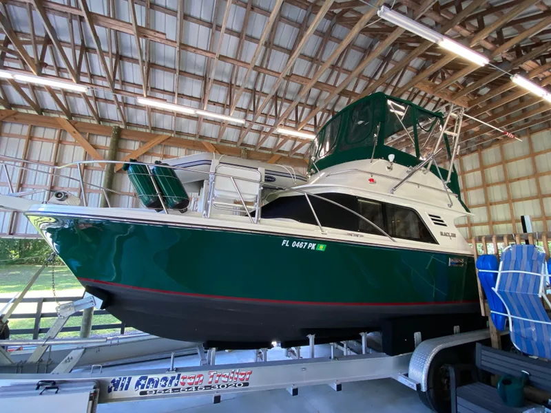 Slide: The Image of 1988 Blackfin 29 Flybridge boat in a wooden boathouse on a trailer. - 120