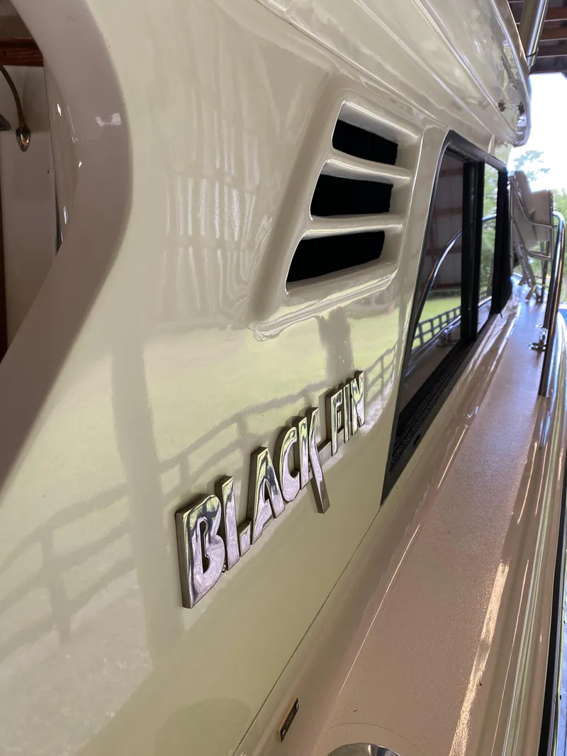 Slide: The Image of 1988 Blackfin 29 Flybridge boat side view with logo and window details. - 12