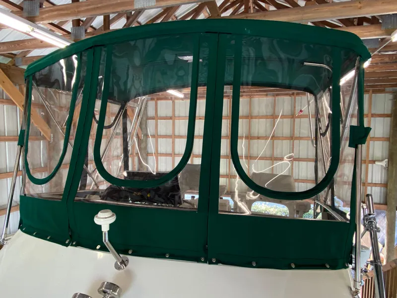 Slide: The Image of 1988 Blackfin 29 Flybridge with green canvas enclosure in a wooden boathouse. - 15