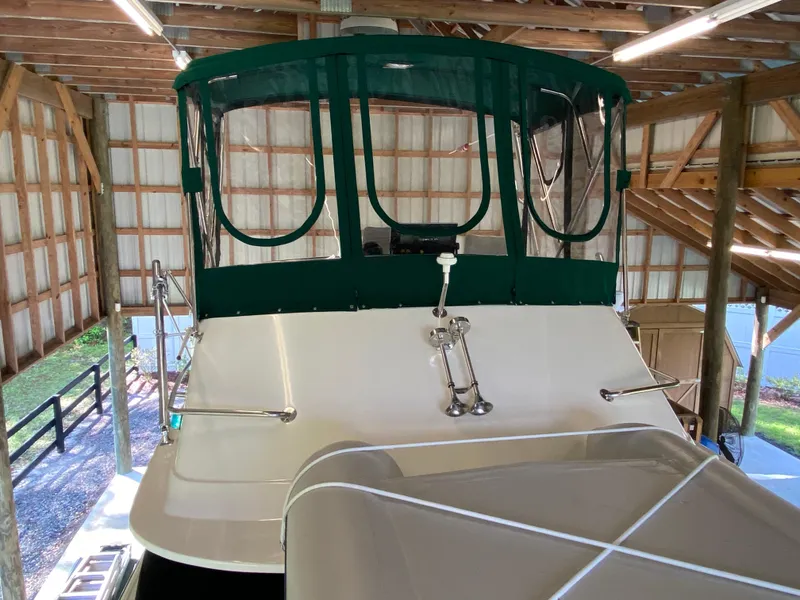 Slide: The Image of 1988 Blackfin 29 Flybridge boat under a wooden shelter with green canopy. - 16