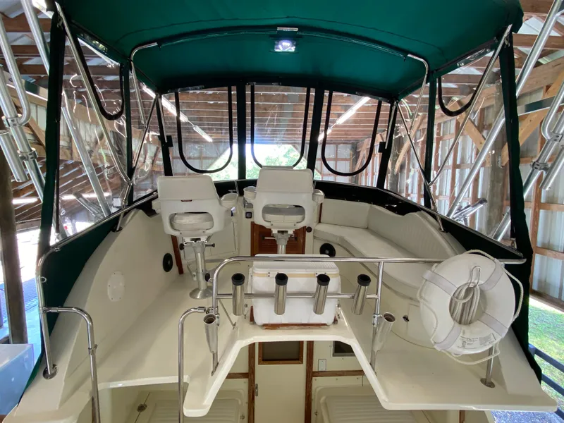 Slide: The Image of 1988 Blackfin 29 Flybridge interior with seating, helm, and green canopy. - 18