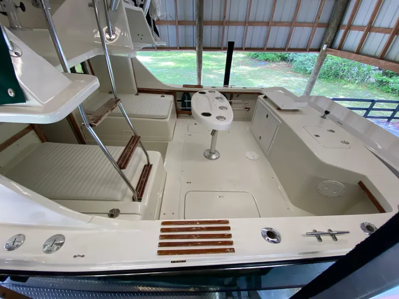 Slide: The Image of 1988 Blackfin 29 Flybridge boat interior with seating and fishing rod holders. - 24