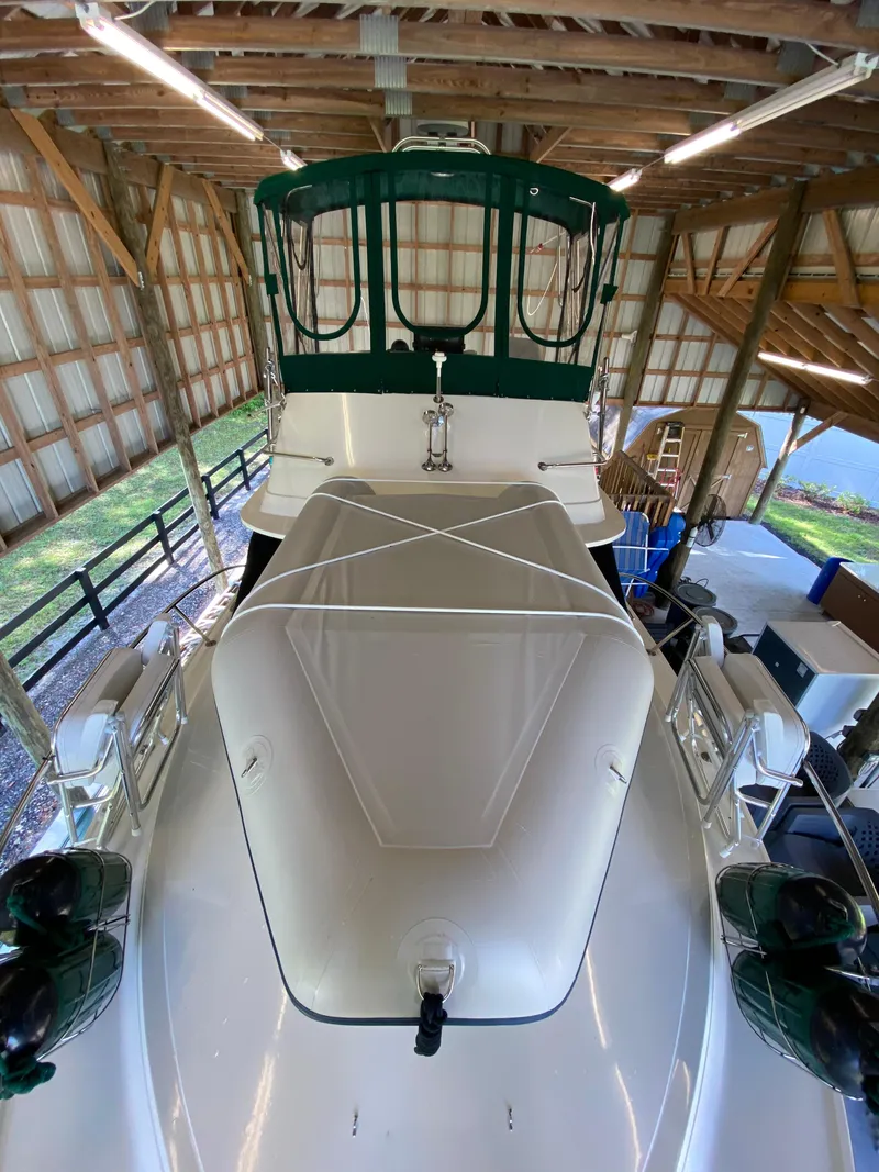 Slide: The Image of 1988 Blackfin 29 Flybridge boat under a wooden shelter, showcasing its deck and flybridge. - 4