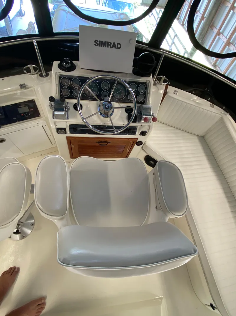 Slide: The Image of 1988 Blackfin 29 Flybridge helm with Simrad electronics and white seating. - 46
