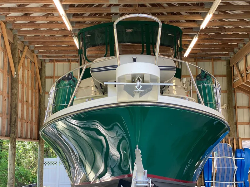 Slide: The Image of 1988 Blackfin 29 Flybridge boat in a wooden boathouse, front view. - 7