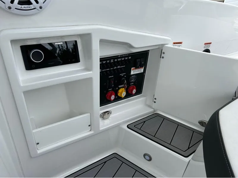 Slide: The Image of 2022 Monterey 298 Super Sport boat control panel with audio system and storage. - 23