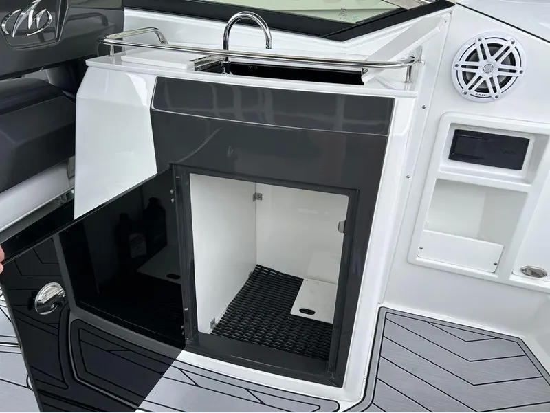 Slide: The Image of 2022 Monterey 298 Super Sport boat interior with open storage compartment and speaker. - 24