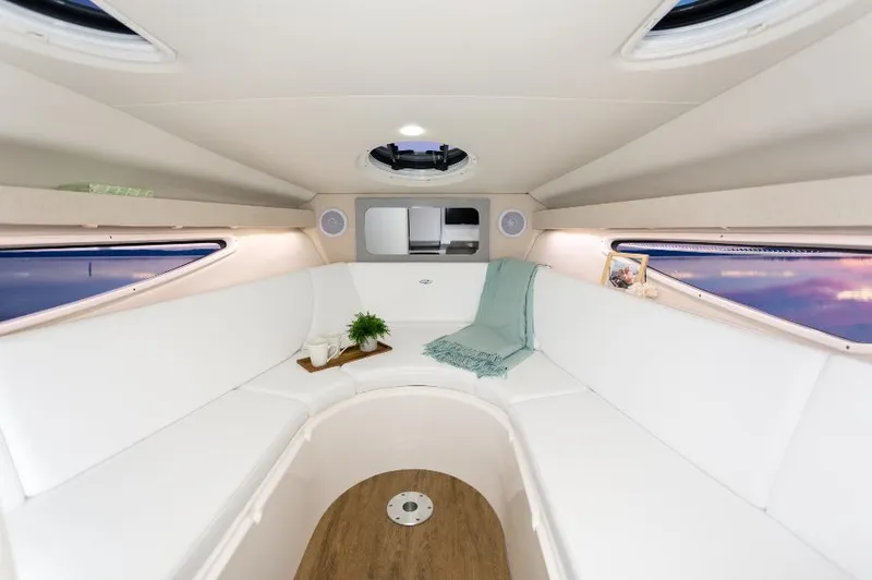 Slide: The Image of 2023 Regal 28 Express cabin interior with white seating and wood flooring. - 13