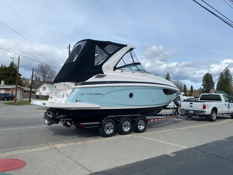 Slide: The Image of 2023 Regal 28 Express boat on a trailer, being towed by a white truck. - 2
