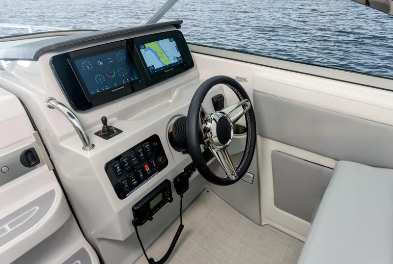 Slide: The Image of 2023 Regal 28 Express boat helm with dual navigation screens and steering wheel. - 4