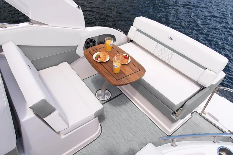 Slide: The Image of 2023 Regal 28 Express boat interior with dining setup on the water. - 6