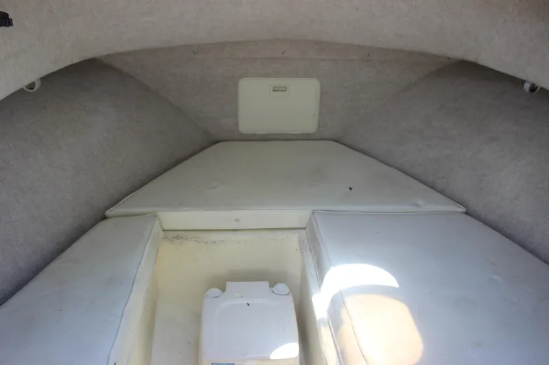 Slide: The Image of 1996 Parker 2110 Walkaround boat cabin interior with white cushions. - 21
