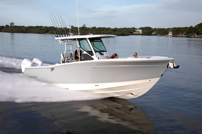 The Image of 2026 Blackfin 302 CC boat cruising on calm water with passengers onboard. - 0