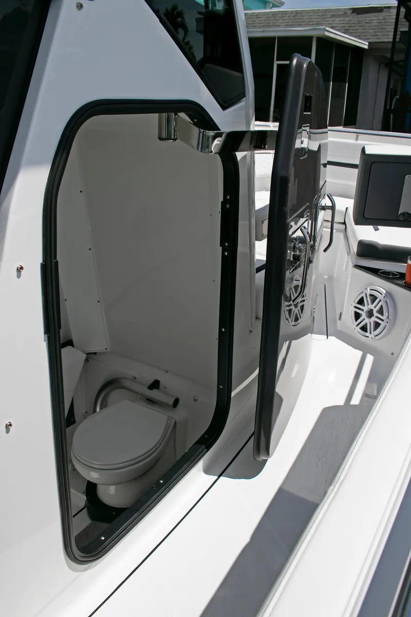 Slide: The Image of 2026 Blackfin 302 CC boat with open cabin door revealing interior toilet. - 16