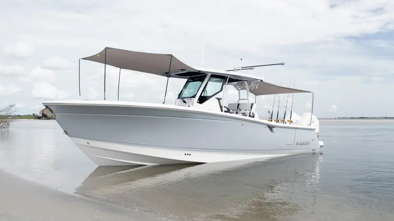Slide: The Image of 2026 Blackfin 302 CC boat with canopy, anchored on a calm beach. - 21