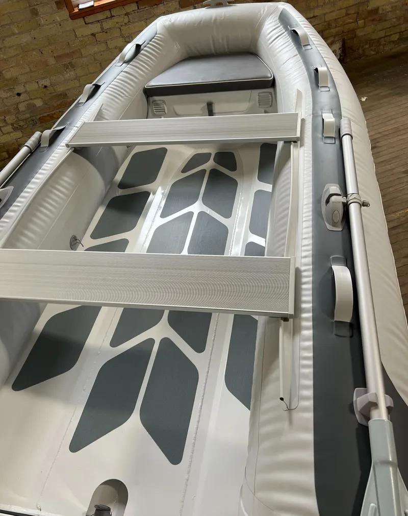 Slide: The Image of 2023 Gala A330D inflatable boat with grey and white interior, wooden seat, and oar holders. - 2