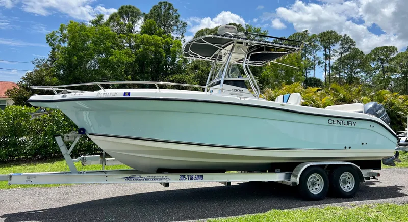 Slide: The Image of 2005 Century 2600 Center Console boat on a trailer, parked outdoors. - 1