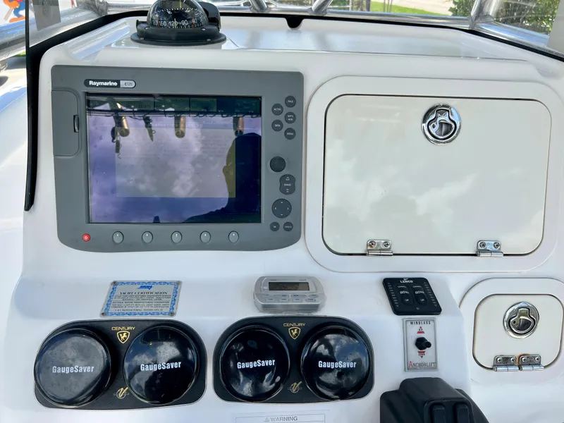 Slide: The Image of 2005 Century 2600 Center Console boat dashboard with Raymarine display and gauges. - 23