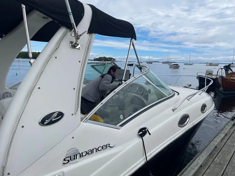 Slide: The Image of 2007 Sea Ray 260 Sundancer docked at a marina with a person onboard. - 11
