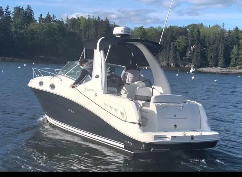 Slide: The Image of 2007 Sea Ray 260 Sundancer cruising on a lake with forested shoreline. - 7