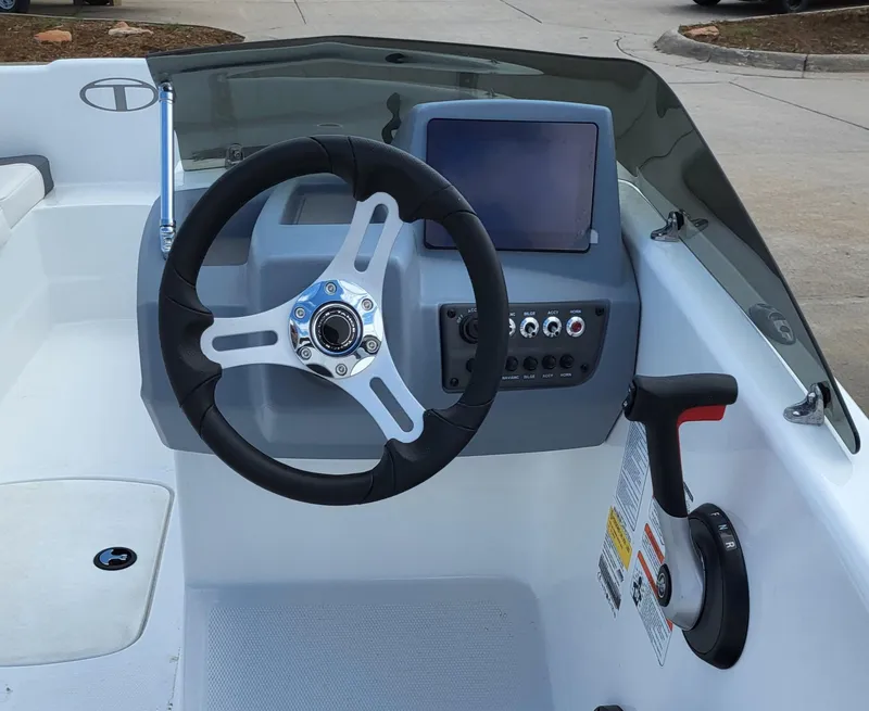 Slide: The Image of 2023 Tahoe T16 boat dashboard with steering wheel and control panel. - 3