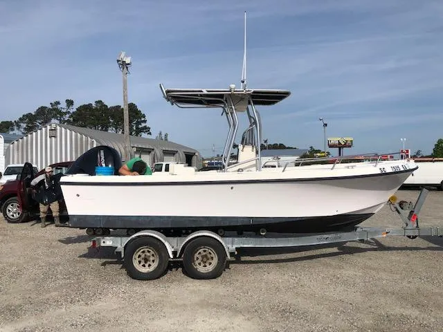 Slide: The Image of 2005 May-Craft 2000 CC boat on a trailer in a parking lot. - 2