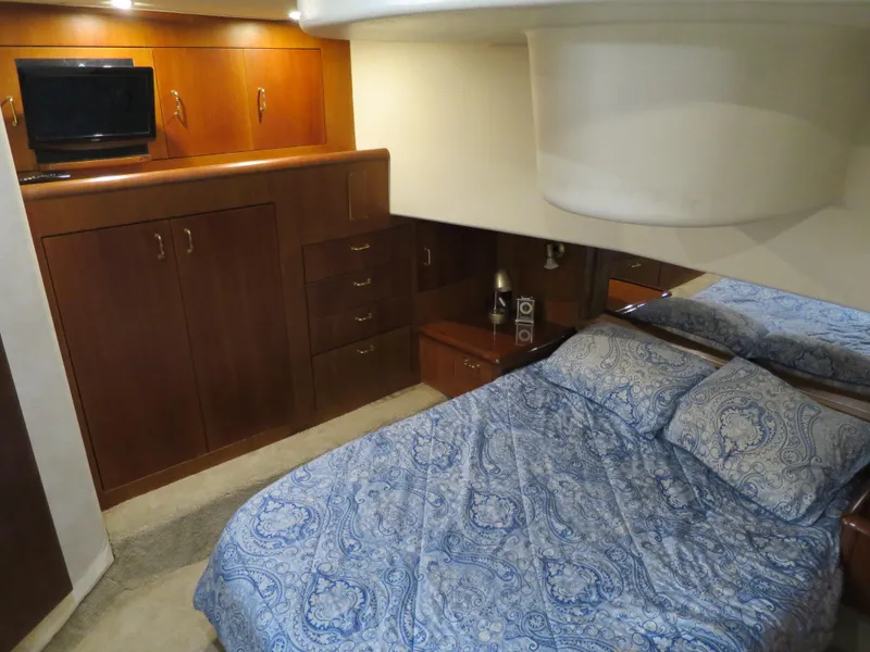 Slide: The Image of 1999 Ocean Yachts bedroom with wooden cabinetry and blue patterned bedding. - 10