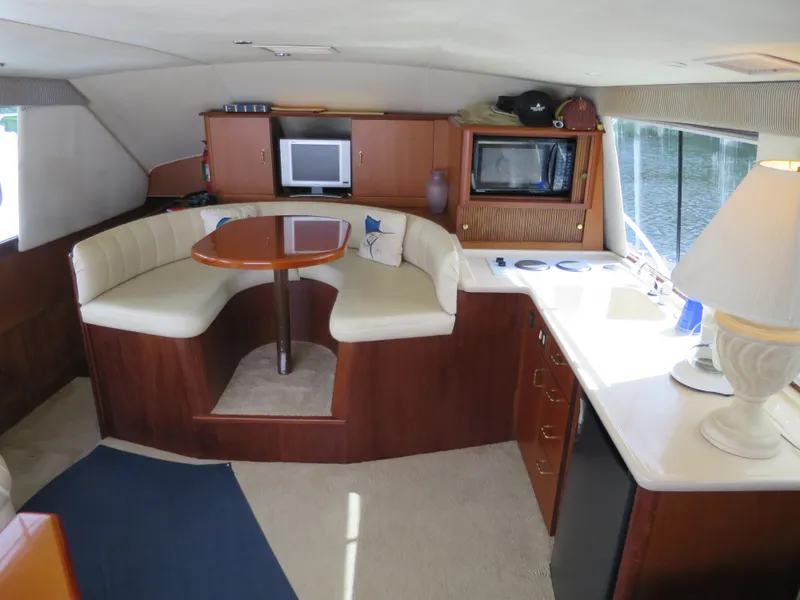 Slide: The Image of Interior of a 1999 Ocean Yachts boat with dining area, kitchenette, and TV. - 6