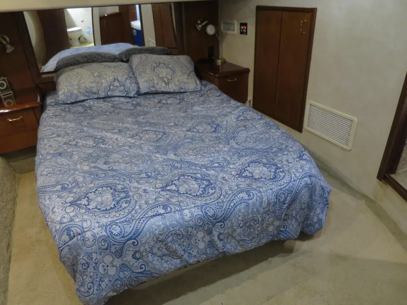 Slide: The Image of 1999 Ocean Yachts bedroom with blue paisley bedding and wooden cabinets - 9