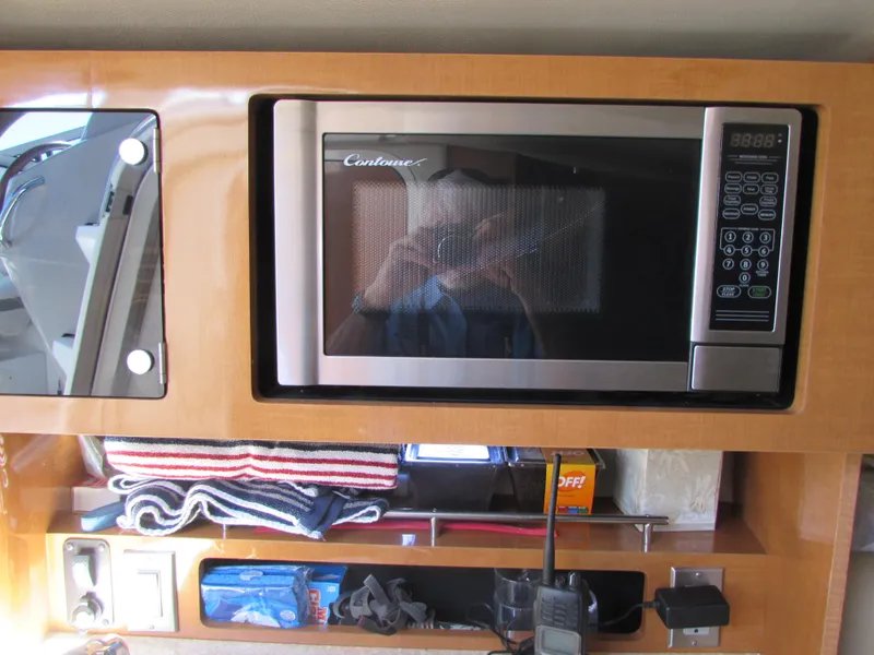 Slide: The Image of Microwave and storage area inside a 2012 Chaparral Signature boat. - 16