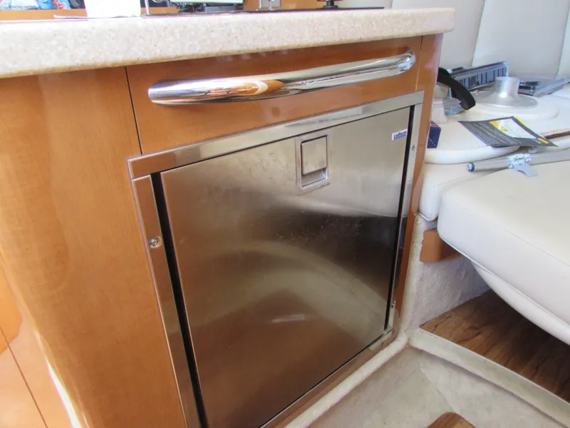 Slide: The Image of Chaparral Signature 2012 yacht interior with stainless steel fridge and wooden cabinetry. - 21