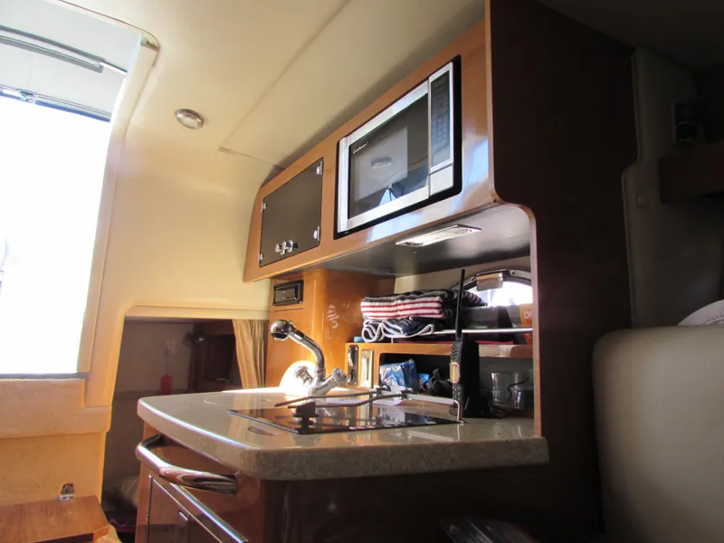 Slide: The Image of 2012 Chaparral Signature boat interior kitchen with microwave and sink. - 25
