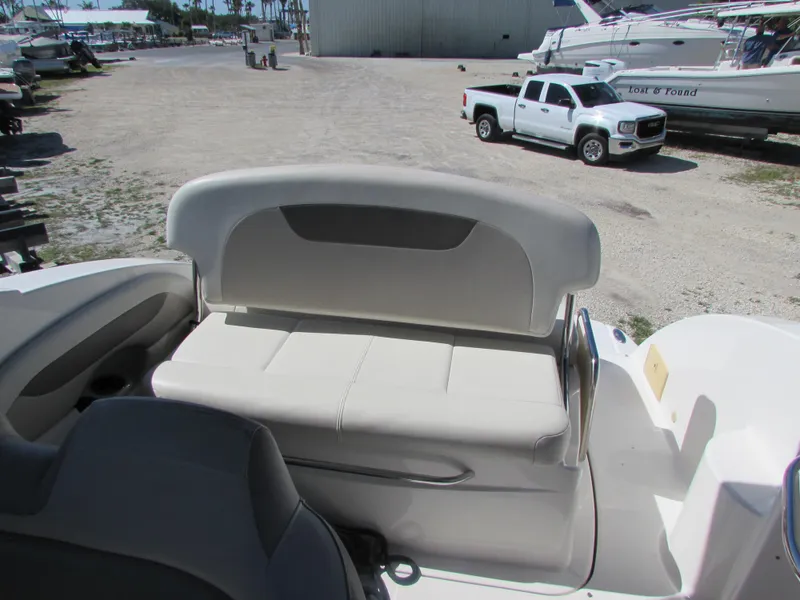 Slide: The Image of 2012 Chaparral Signature boat interior with seating and docked vehicles in the background. - 27
