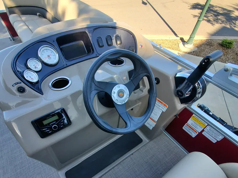 Slide: The Image of 2023 Sun Tracker Party Barge 18 DLX steering console with gauges and controls. - 2