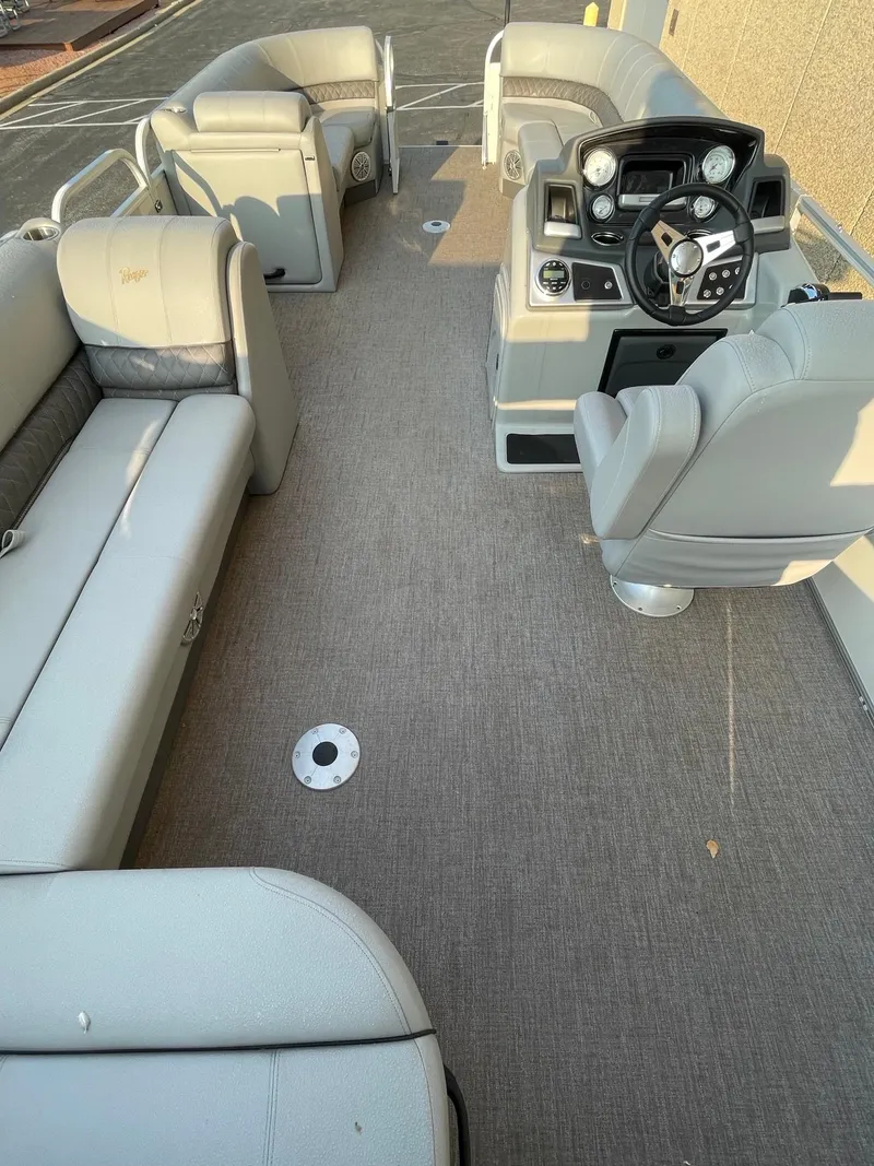 Slide: The Image of 2023 Ranger Reata 220C pontoon boat interior with plush seating and modern dashboard. - 4