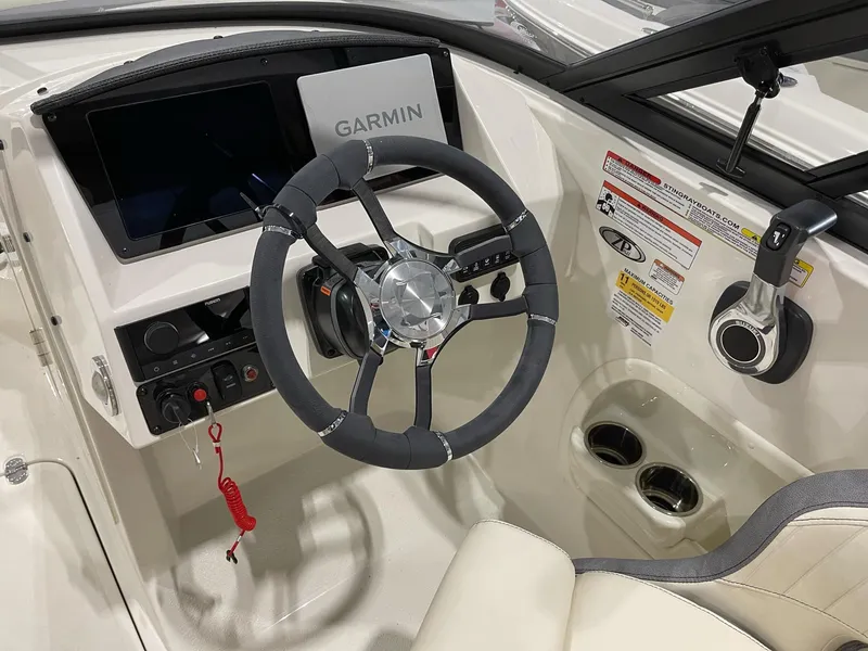 Slide: The Image of 2023 Stingray 211DC boat dashboard with Garmin display and steering wheel. - 12