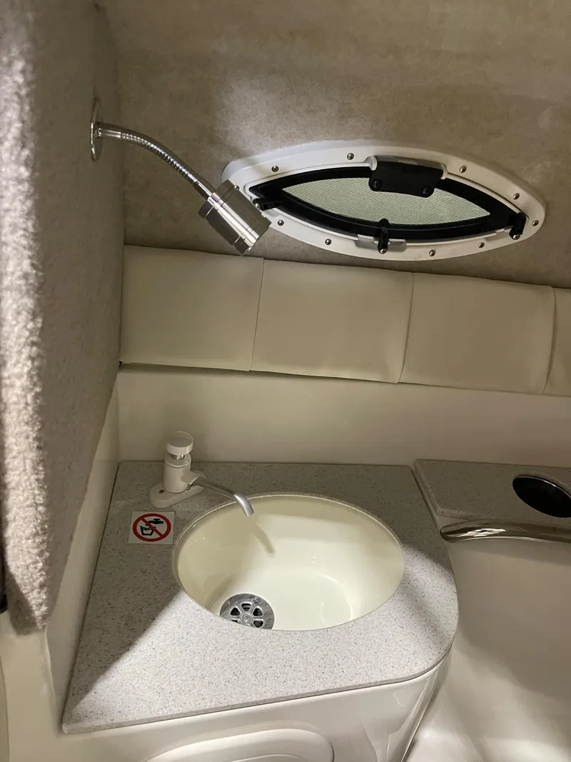 Slide: The Image of 2023 Stingray 211DC boat interior with sink and porthole window. - 17