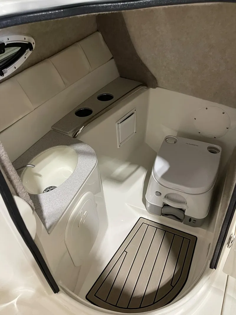 Slide: The Image of 2023 Stingray 211DC boat interior with compact bathroom and sink. - 18