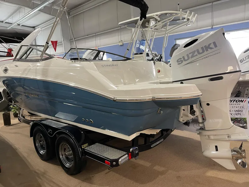 Slide: The Image of 2023 Stingray 211DC boat with Suzuki outboard motor on display in showroom. - 5